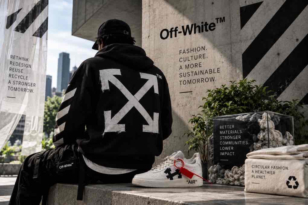 Off-White streetwear display featuring a black arrow hoodie, sneaker, and circular-fashion messaging about materials, reuse, and sustainability.