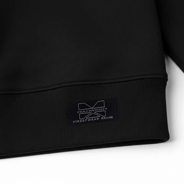 Close-up of Multiversity hem glitch design tag on black sweatshirt
